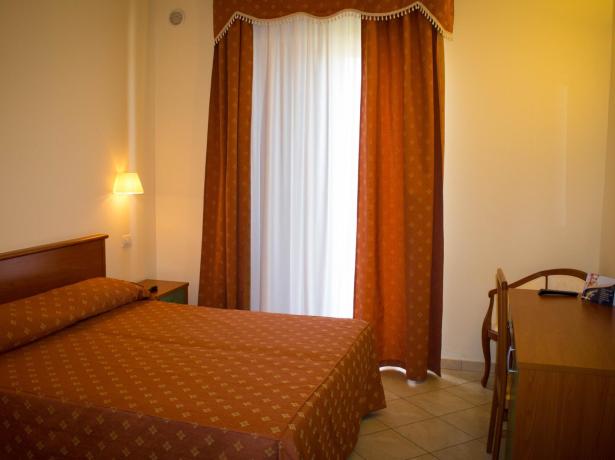 Camera d'albergo con letto matrimoniale e scrivania.