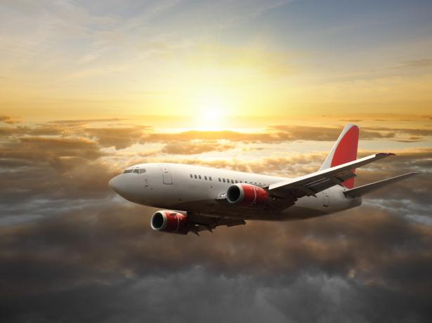 Aereo vola tra le nuvole al tramonto.